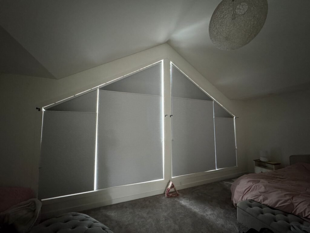 Grey honeycomb blinds installed in a Calgary bedroom for blackout privacy.