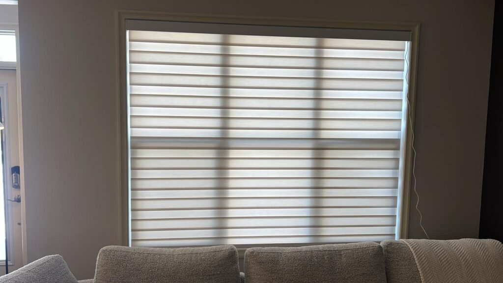 Motorized zebra blinds with dual-shade light control installed by Calgary Blinds Company for a living room.