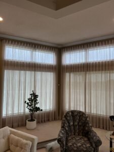Close-up of a wall-mounted S-Pleat drapery rod with decorative finials holding luxury sheer curtains by Calgary Blinds Company.