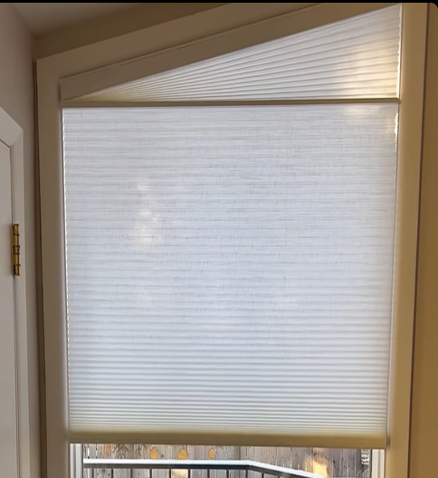 White honeycomb shade with an angled top section above a rectangular lower window