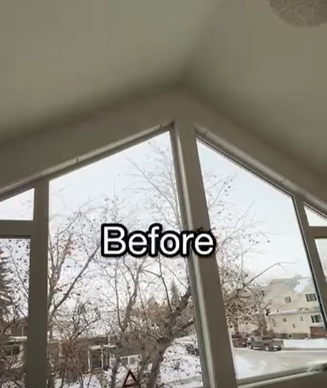 Bare gable bay window with no window covering, looking out at snow
