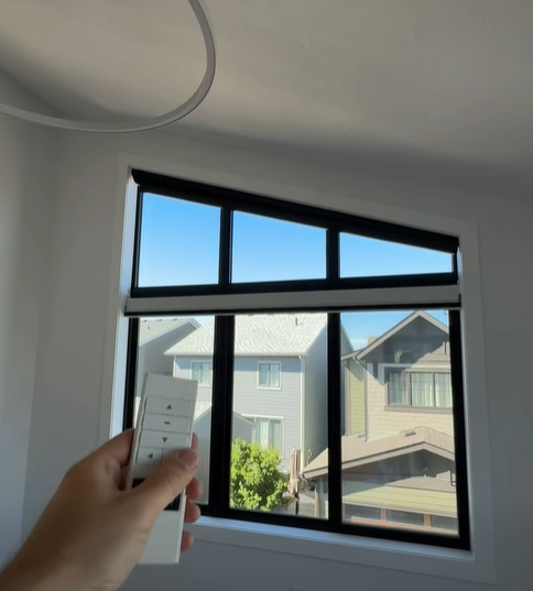 Dark grey triangular honeycomb shades fitted to angled windows in a modern Calgary home